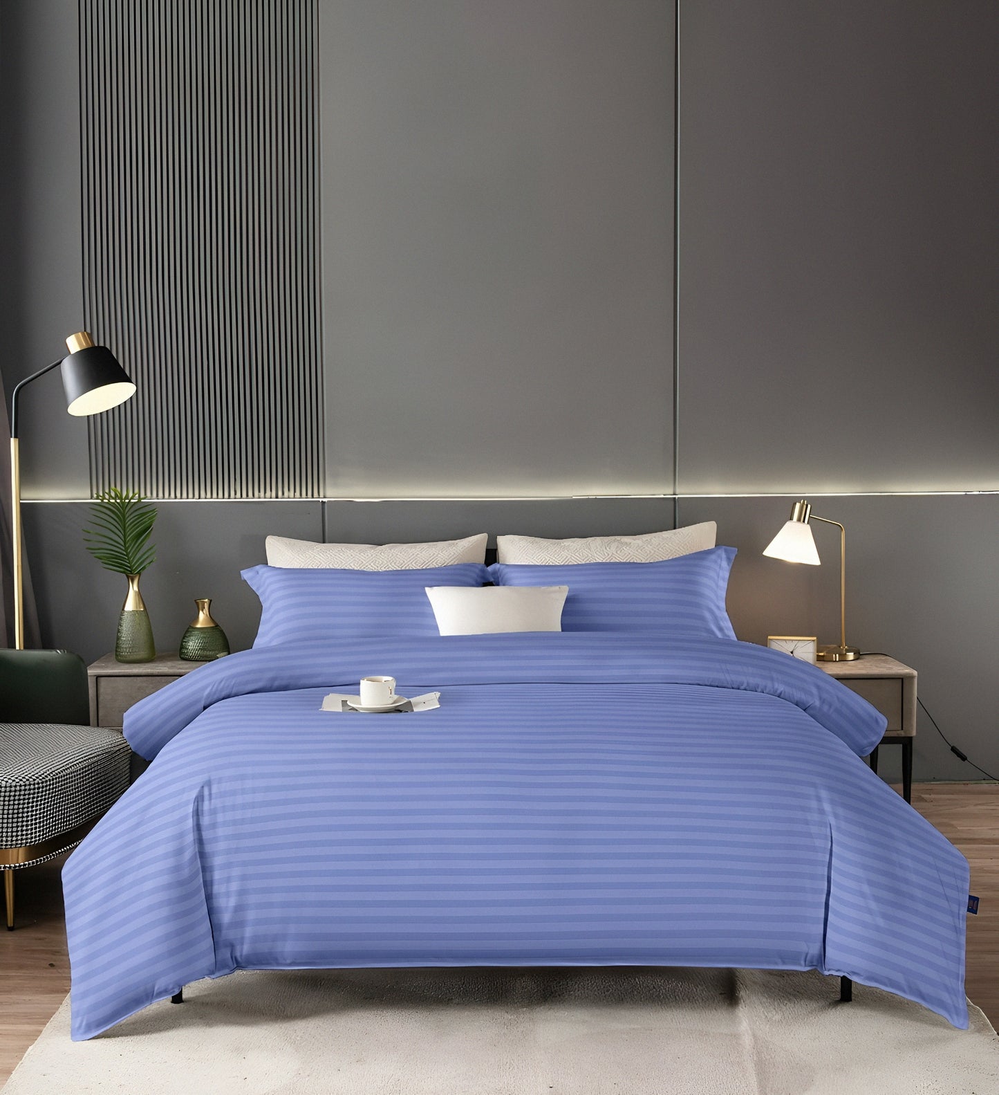 A beautifully made bed with a wrinkle-free charcoal blue microfiber fitted sheet and matching pillowcases.