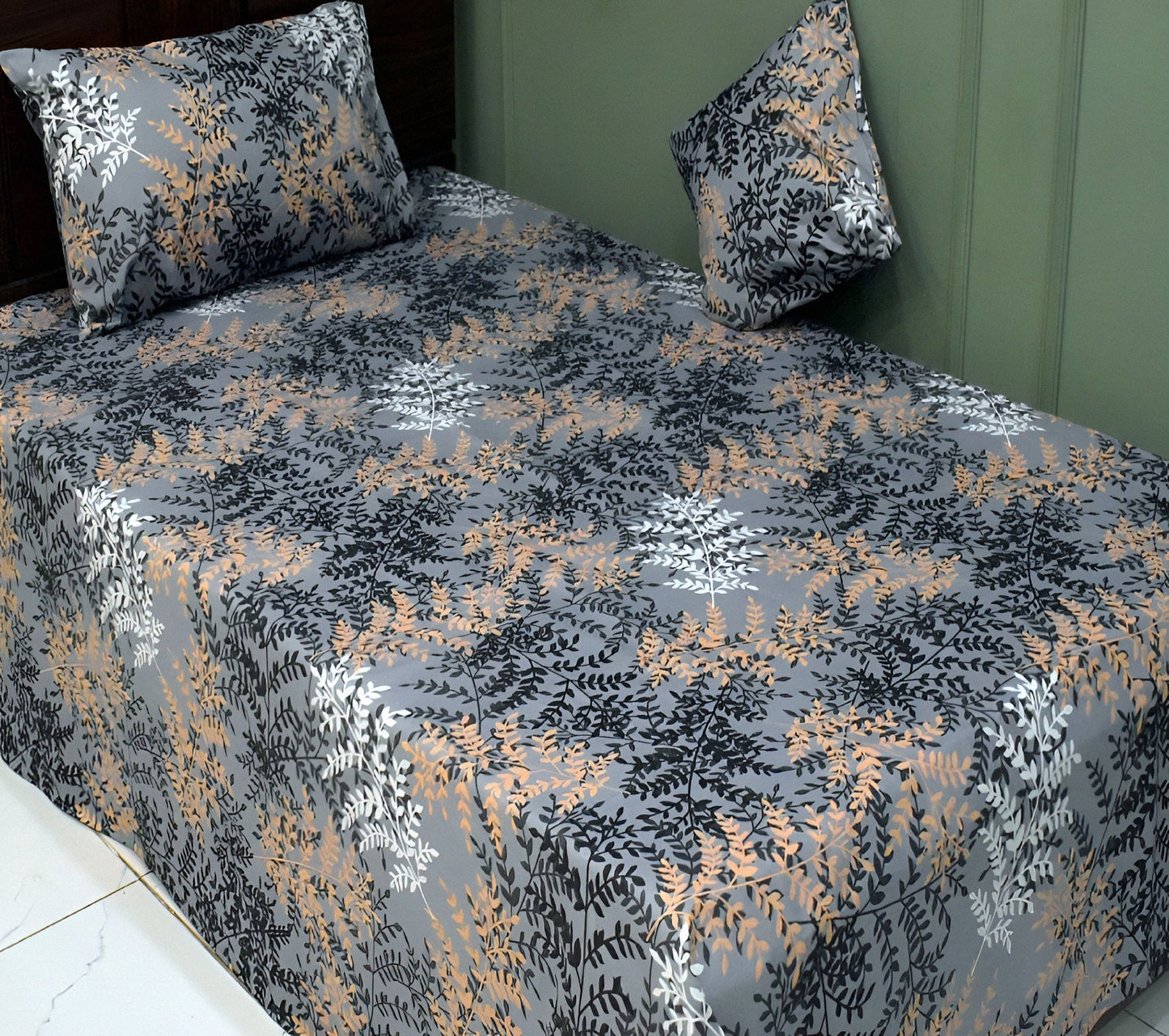 Floral patterned bedspread on a bed with matching pillows.