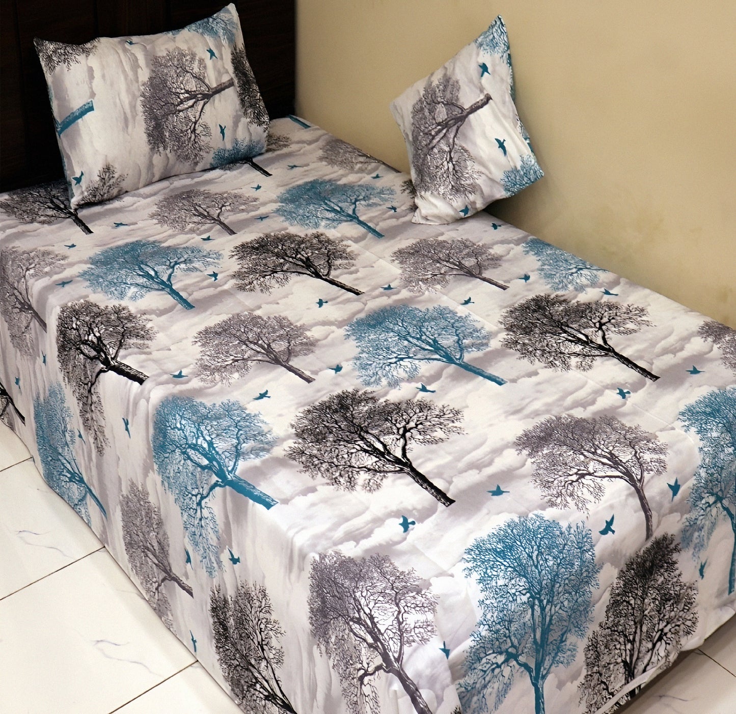 Rolled gray cotton blend bedsheet with a tree print design, highlighting the fabric’s texture.