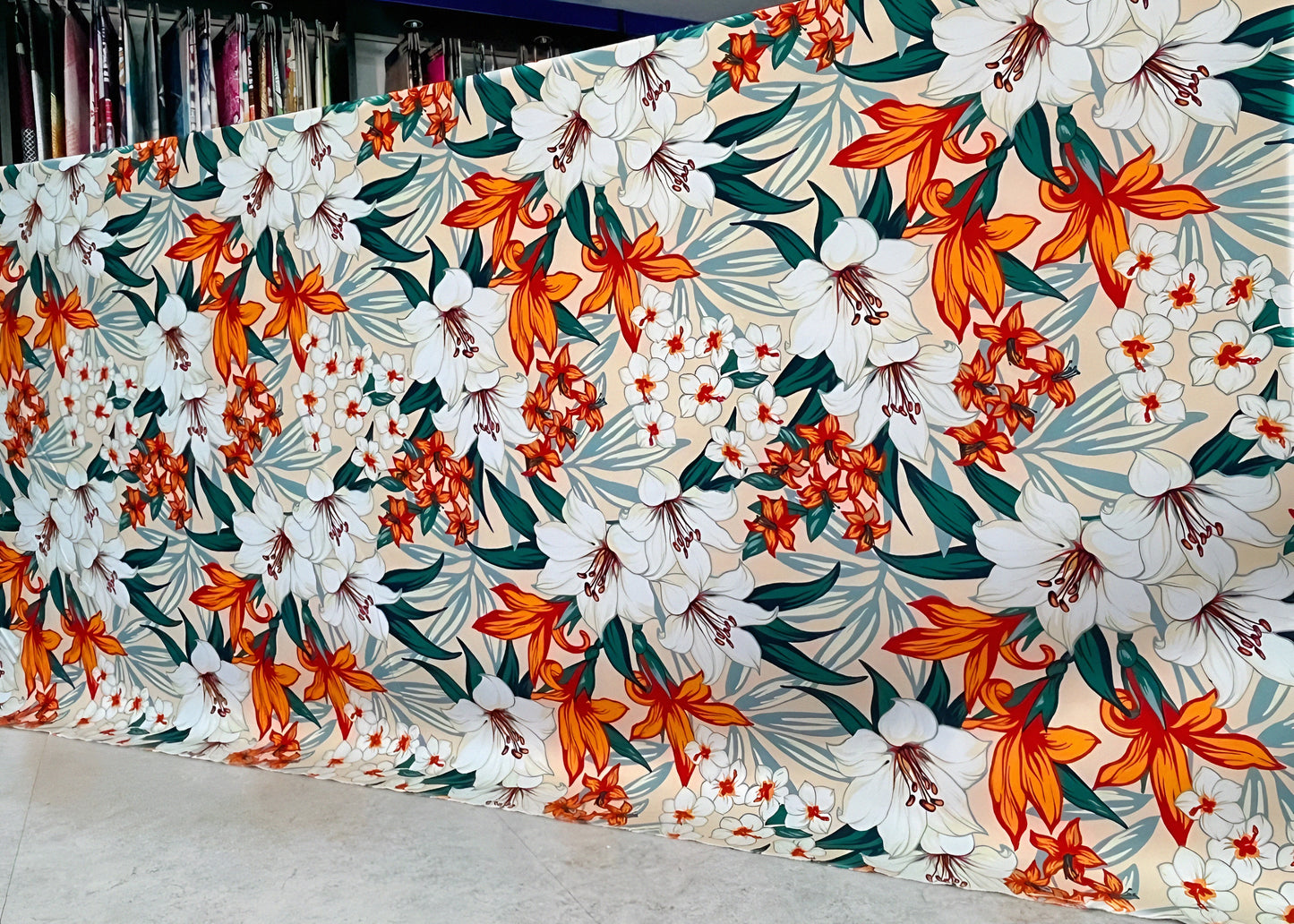 Marjan3x luxury floral bedsheet roll with white & orange lilies — wholesale sizes available. شرشف بنقشة زهور أبيض وبرتقالي، متاح بالجملة وبمقاسات متعددة