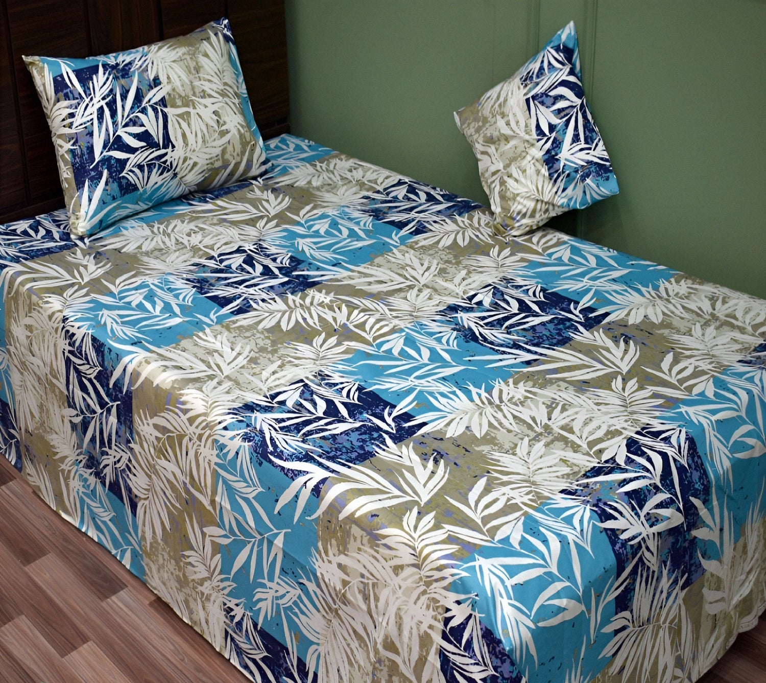 Cyan and gray bedsheet roll spread on bed showing leaf pattern and texture.