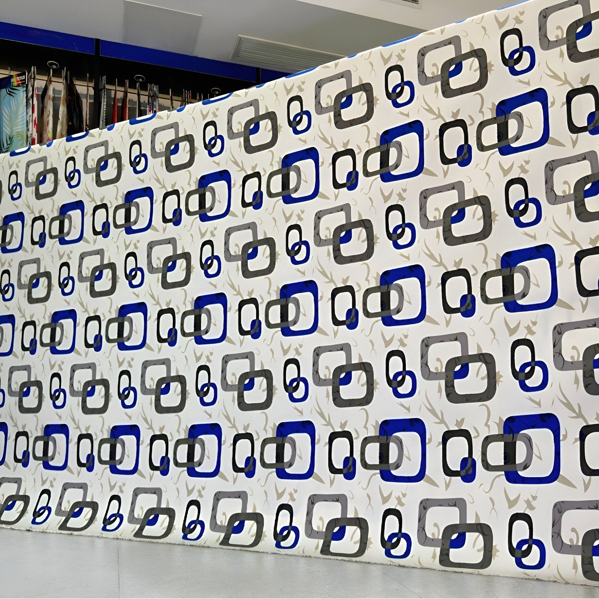 Wall with geometric pattern of blue, black, and gray squares in a store setting.