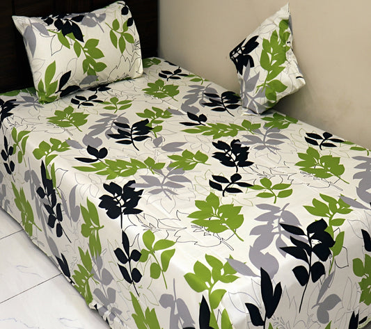 Single bed dressed with green leaf printed cotton bedsheet and matching pillow cover.