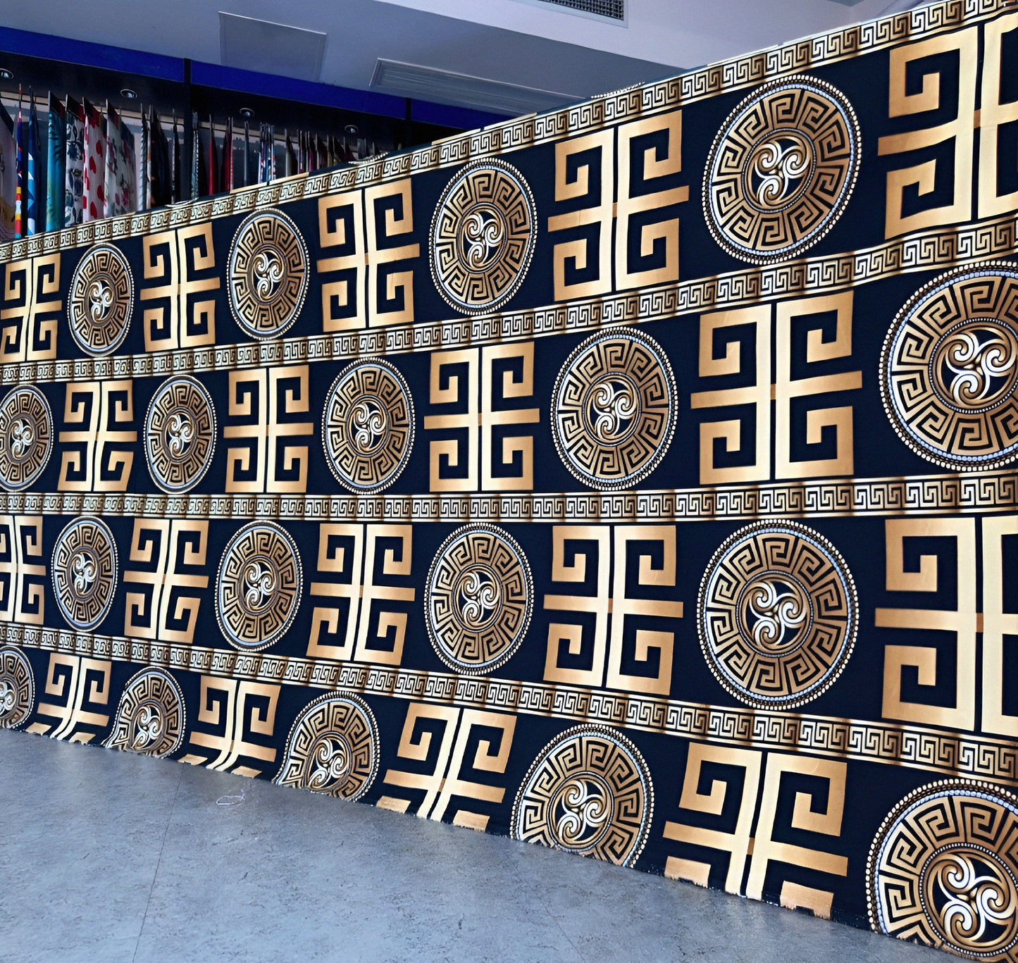 Black bedsheet with gold geometric pattern displayed in showroom — luxury solid-color bedding.