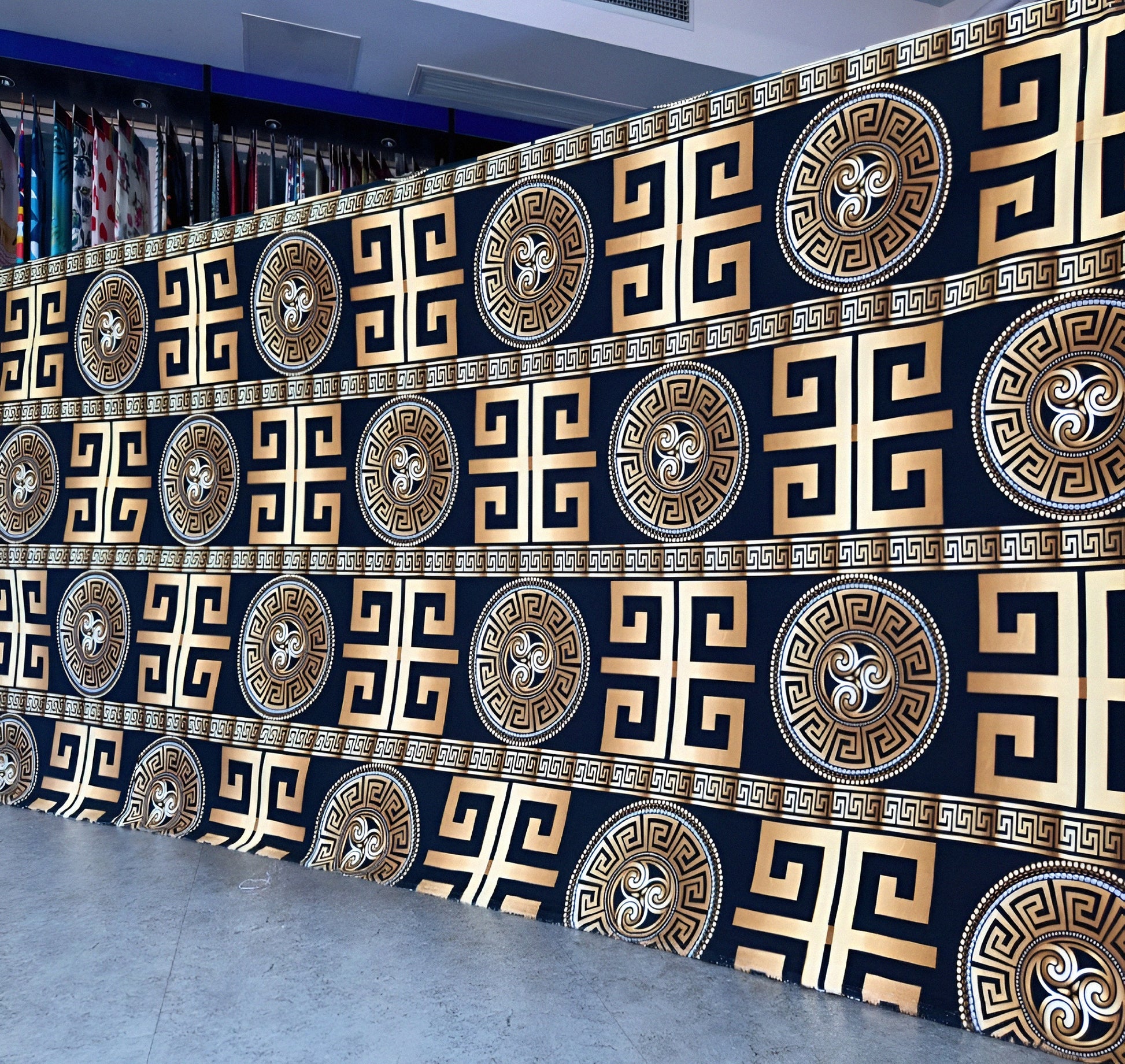 Black bedsheet with gold geometric pattern displayed in showroom — luxury solid-color bedding.
