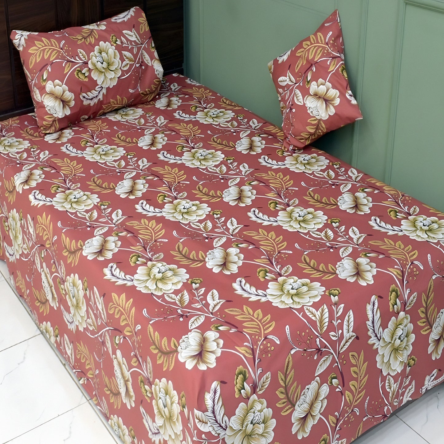 Floral patterned bedspread on a bed with matching pillows.
