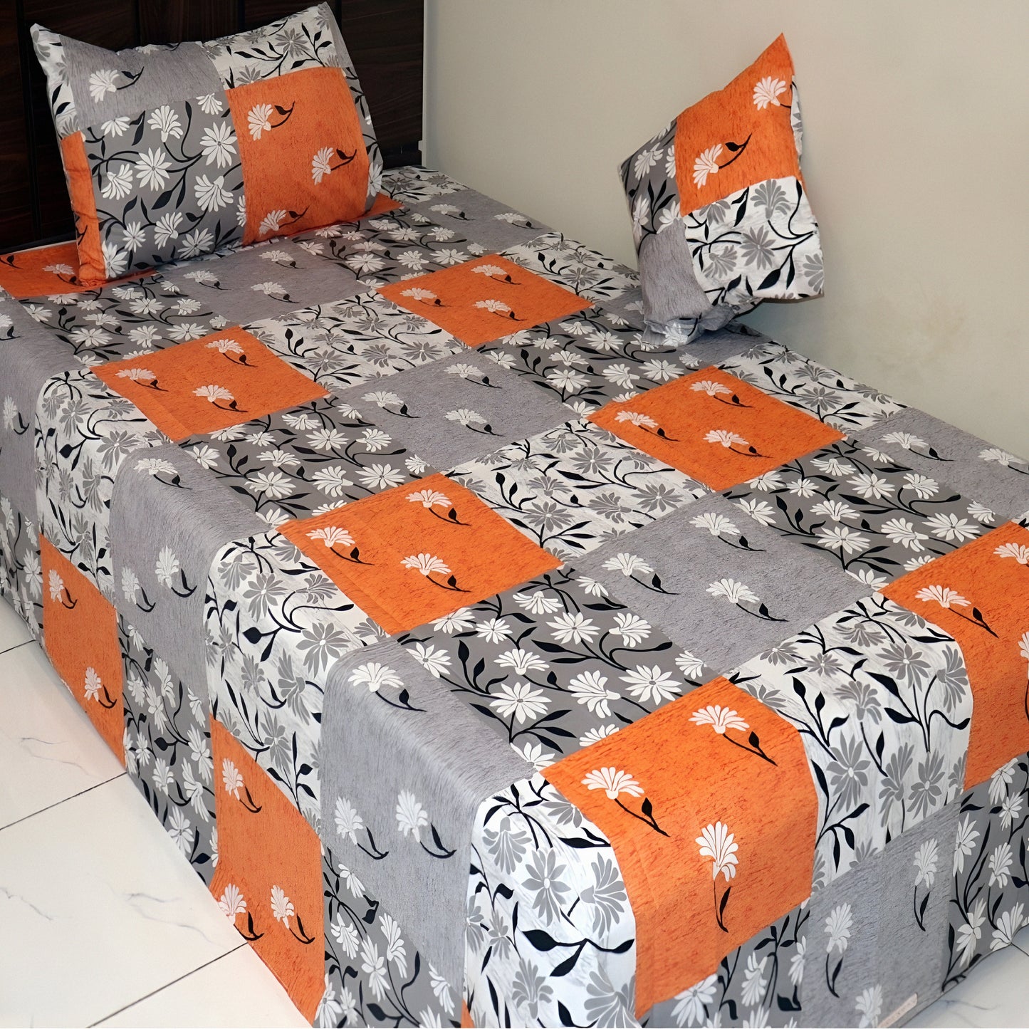 Luxury Off-white floral cotton bedsheet with grey and orange patchwork design.