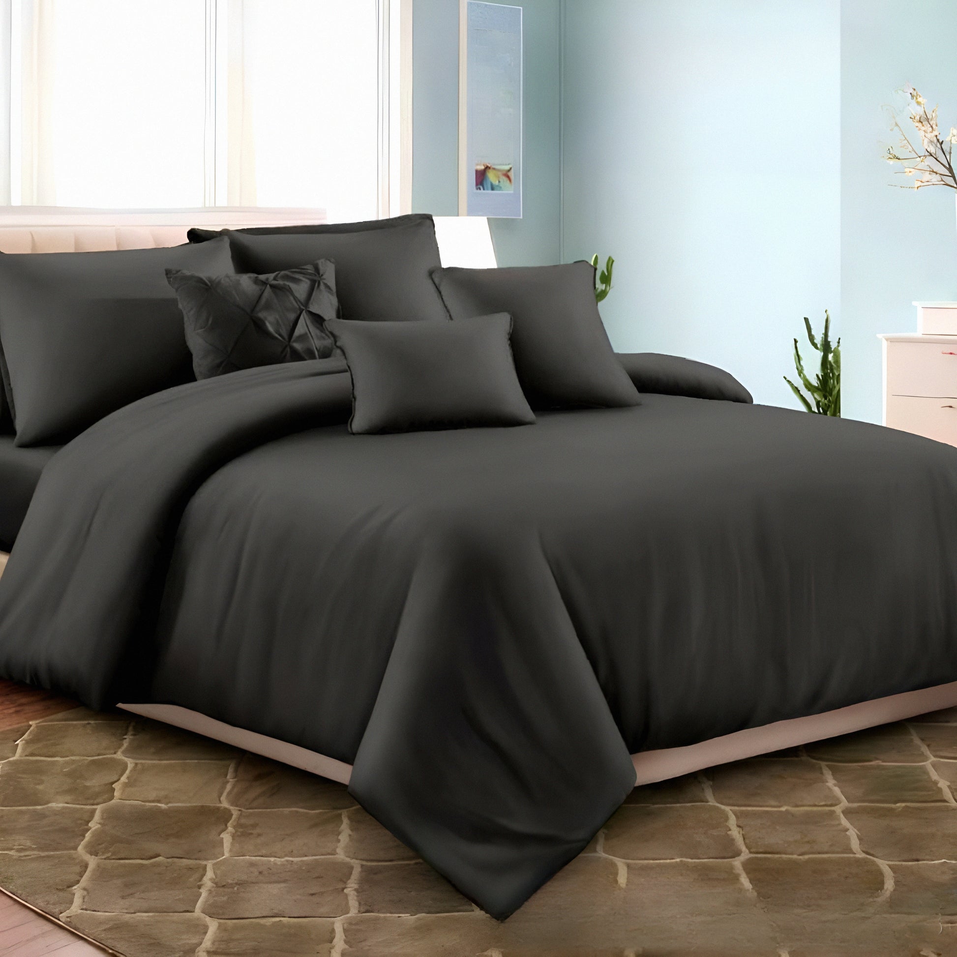 Dark gray bedding set on a bed in a bedroom with light blue walls and a window.
