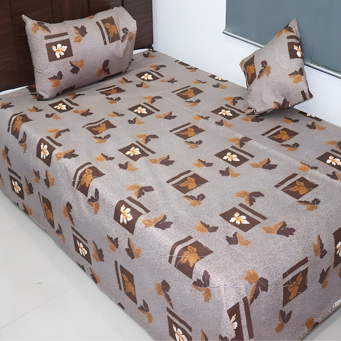 Patterned bedspread with pillows on a bed in a room setting