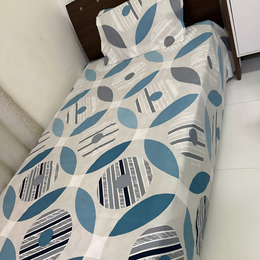 Teal geometric bedsheet with circular pattern on a single bed — Marjan3x UAE
